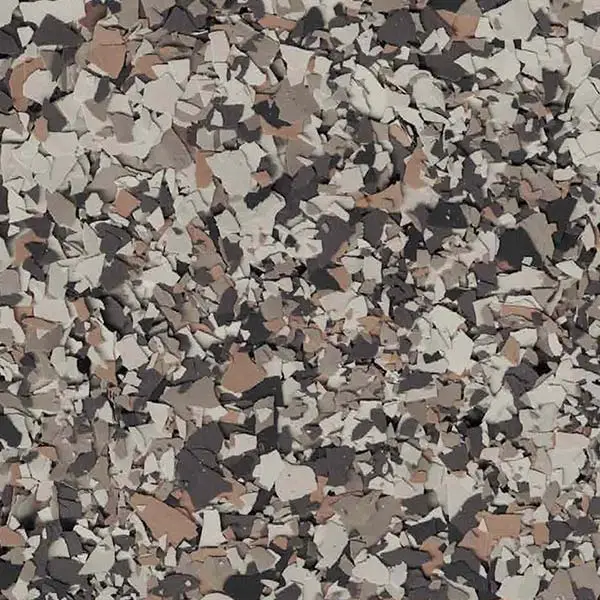 The image shows a close-up of a textured surface featuring a scattered mosaic of brown, gray, and beige flakes, creating a camouflaged effect.